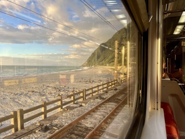 車窓から見る朝日に照らされた東海岸の海岸線