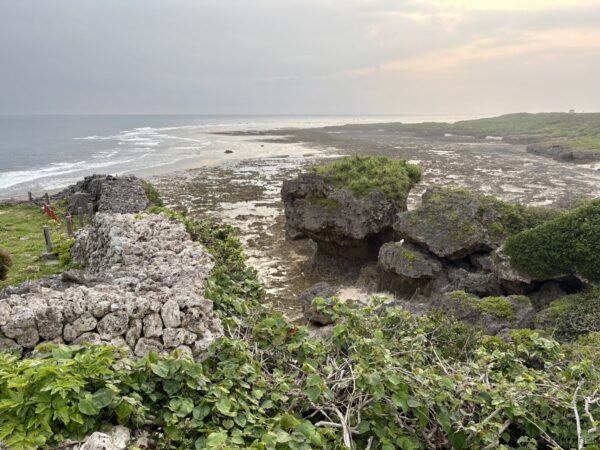 具志川城跡から広がる岩礁海岸。珊瑚礁の礁原が夕映えに照らされ、白波が打ち寄せる糸満市喜屋武の荒々しい海岸線。