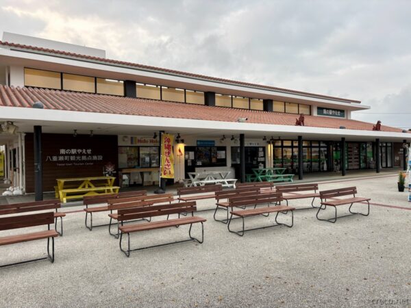 八重瀬町「道の駅やえせ」外観。赤瓦屋根の沖縄風駅舎と「海ぶどう」の幟、港川遺跡公園近くの休憩スポット。
