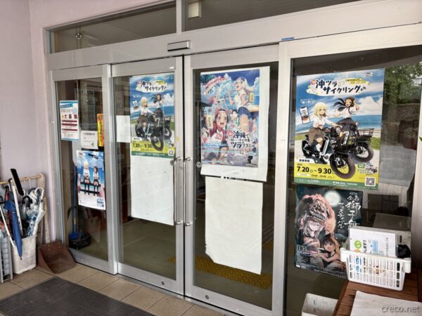 具志川公民館入口のガラス扉に貼られた「沖ブラサイクリング」ポスター。沖ツラとのコラボ企画を知らせる聖地の内観。