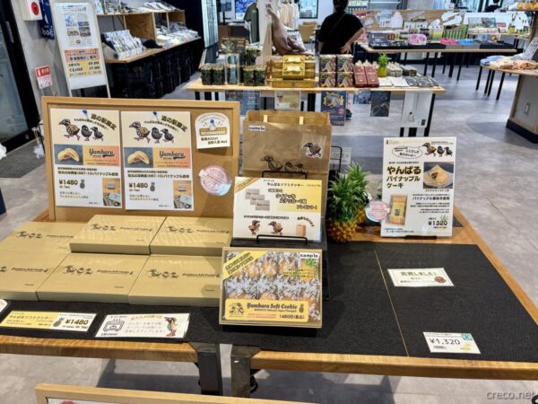 やんばるパイナップルの丘 安波のやんばる土産コーナー。ヤンバルクイナのパッケージの焼き菓子、黒糖パイナップルケーキが並ぶ物販棚。