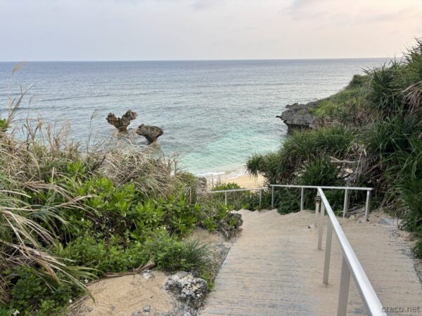 古宇利島・ティーヌ浜（ハートロック）へ下る階段。早朝の海とハート型の奇岩が見える、今帰仁村古宇利島の人気絶景スポットの朝。
