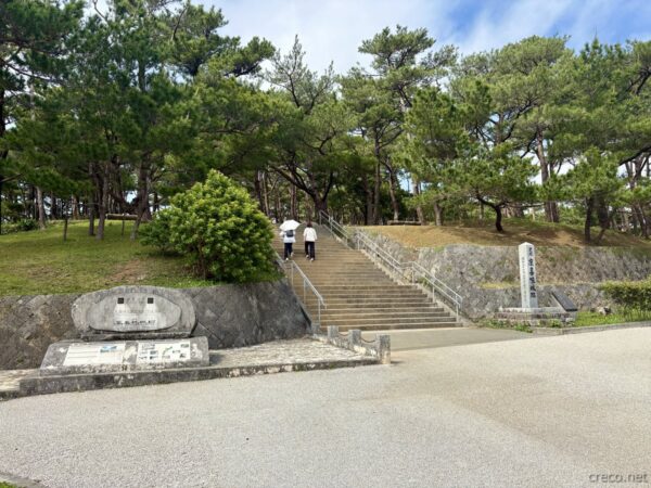 世界遺産・座喜味城跡入口の石段と案内板。松並木に囲まれた登城路、読谷村のグスク文化遺産の玄関口。