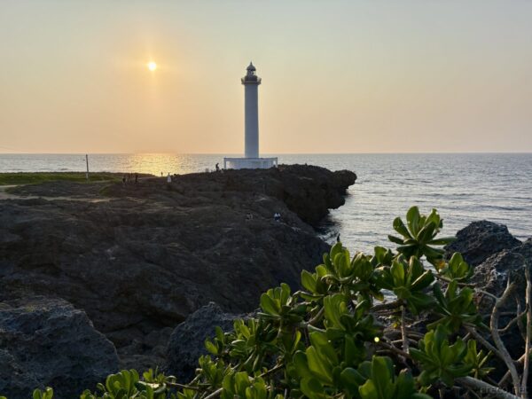 残波岬灯台の夕日バックショット。灯台とアダンのシルエット、夕焼け空のグラデーション、読谷村のサンセット。
