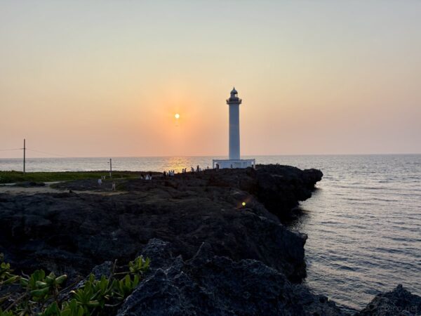 残波岬から北西方向を望む夕景。高い断崖と穏やかな東シナ海、雲の間から差す夕陽、沖縄西海岸の絶景。