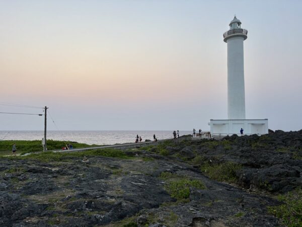 残波岬で出会った長毛の茶トラ島猫。レンガ敷きの縁石に寝そべる灯台近くの野良猫、夕暮れの癒しの出会い。
