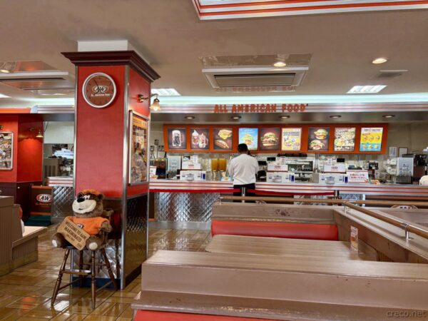 A&W牧港店のカウンターと注文コーナー「ALL AMERICAN FOOD」。A&Wルートベアのマスコットとメニュー、店内の中央カウンター。