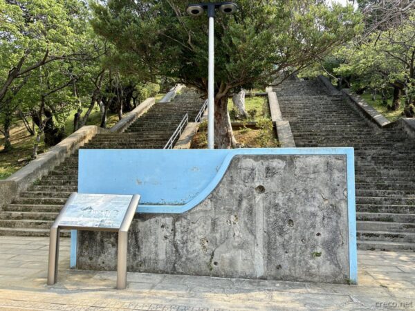 浦添前田高地公園のコンクリート擁壁と階段。青緑色の壁と登り口、沖縄戦の激戦地ハクソー・リッジの遺構。