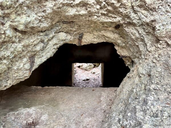 前田高地の自然壕の内部を覗く。石灰岩の洞窟の向こう側に光が見える、沖縄戦で使われた防空壕の内観。
