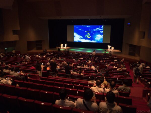 飯能市市民会館ホール内、ヤマノススメ ファンミーティング、舞台映像と満員の客席