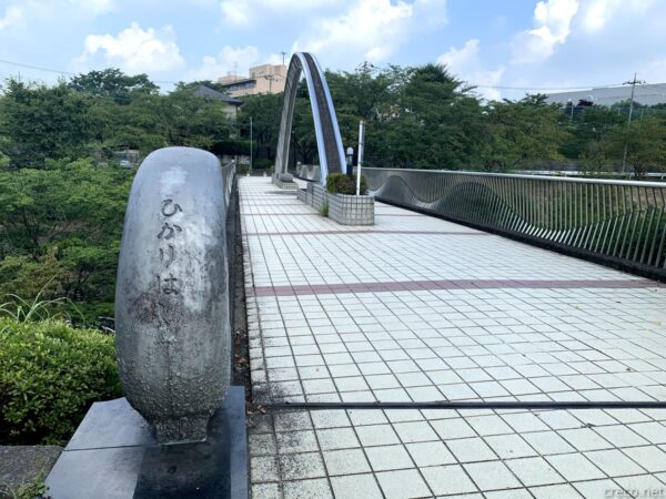 ひかりばし、白いアーチ型の歩道橋と石碑「ひかりばし」
