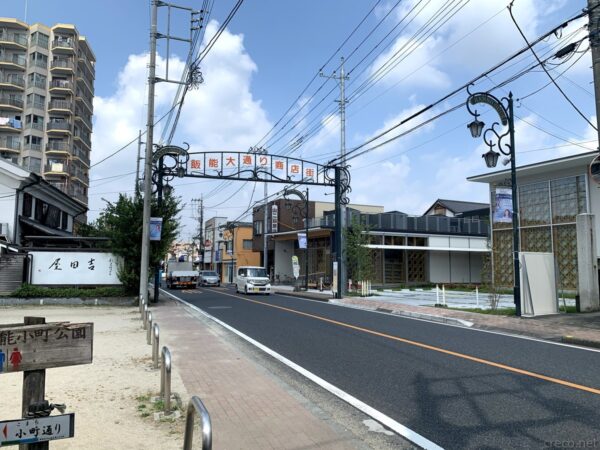 飯能大通り商店街の赤いアーチ看板、「飯能小町通り」の交差点と街路灯