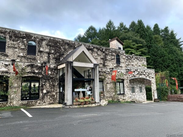 ロックハート城エントランス、スコットランドから移築の石積み城館、赤い旗と緑の樹林に囲まれた古城風の入口