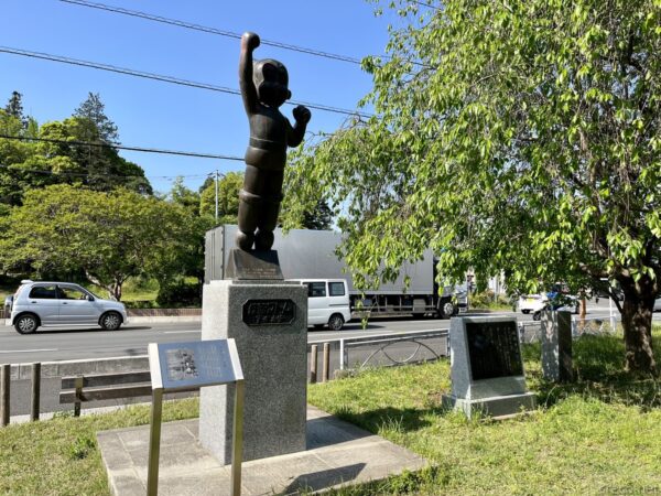 飯能中央公園の鉄腕アトム像、手を上げる黒い銅像と新緑