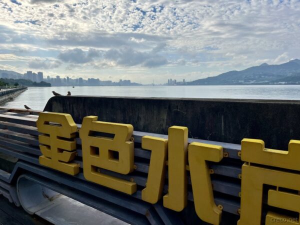 金色水岸の黄色い立体文字、淡水河と街並み