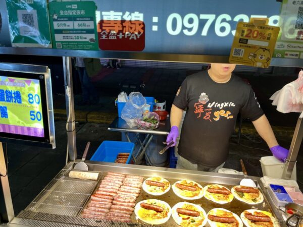 寧夏夜市の屋台でソーセージを焼く店員
