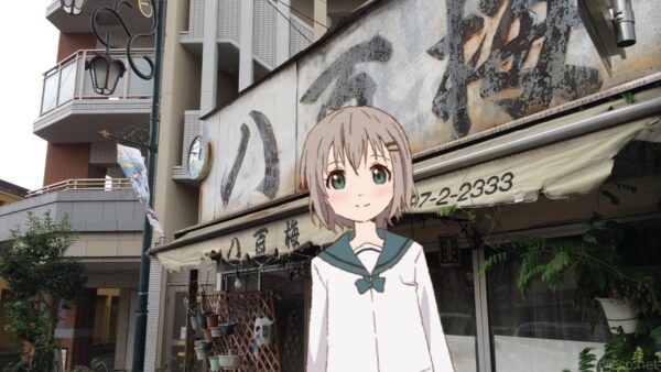 古い木看板の青果店「八百梅」（アニメでは「八百桜」）の店構え、軒先の時計と暖簾