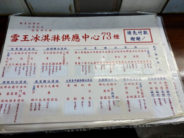 雪王冰淇淋の手書きメニュー看板。「供應中73種」の見出しの下、堅果・水果・蔬菜など多彩なアイス73種の品名がびっしり並ぶ。