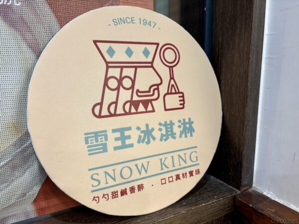 「雪王冰淇淋 SNOW KING SINCE 1947」の丸いロゴ看板。アイスをすくう人物を図案化したレトロなデザインの店頭サイン。